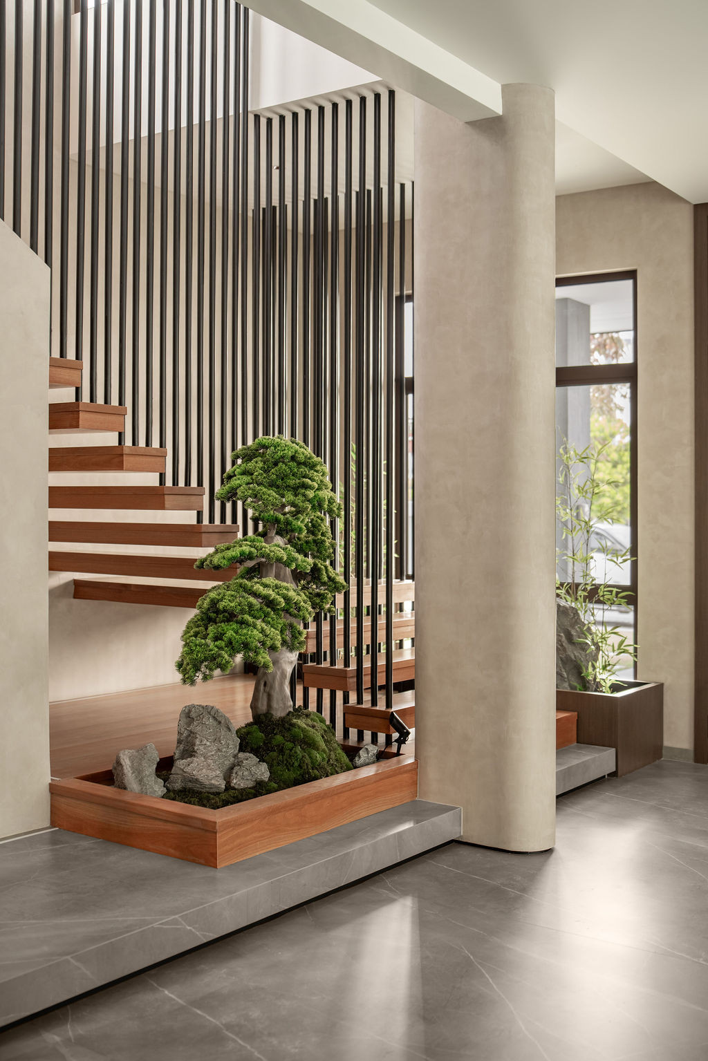 Micro-cement floors extend through the entry, where vertical steel slats frame the staircase