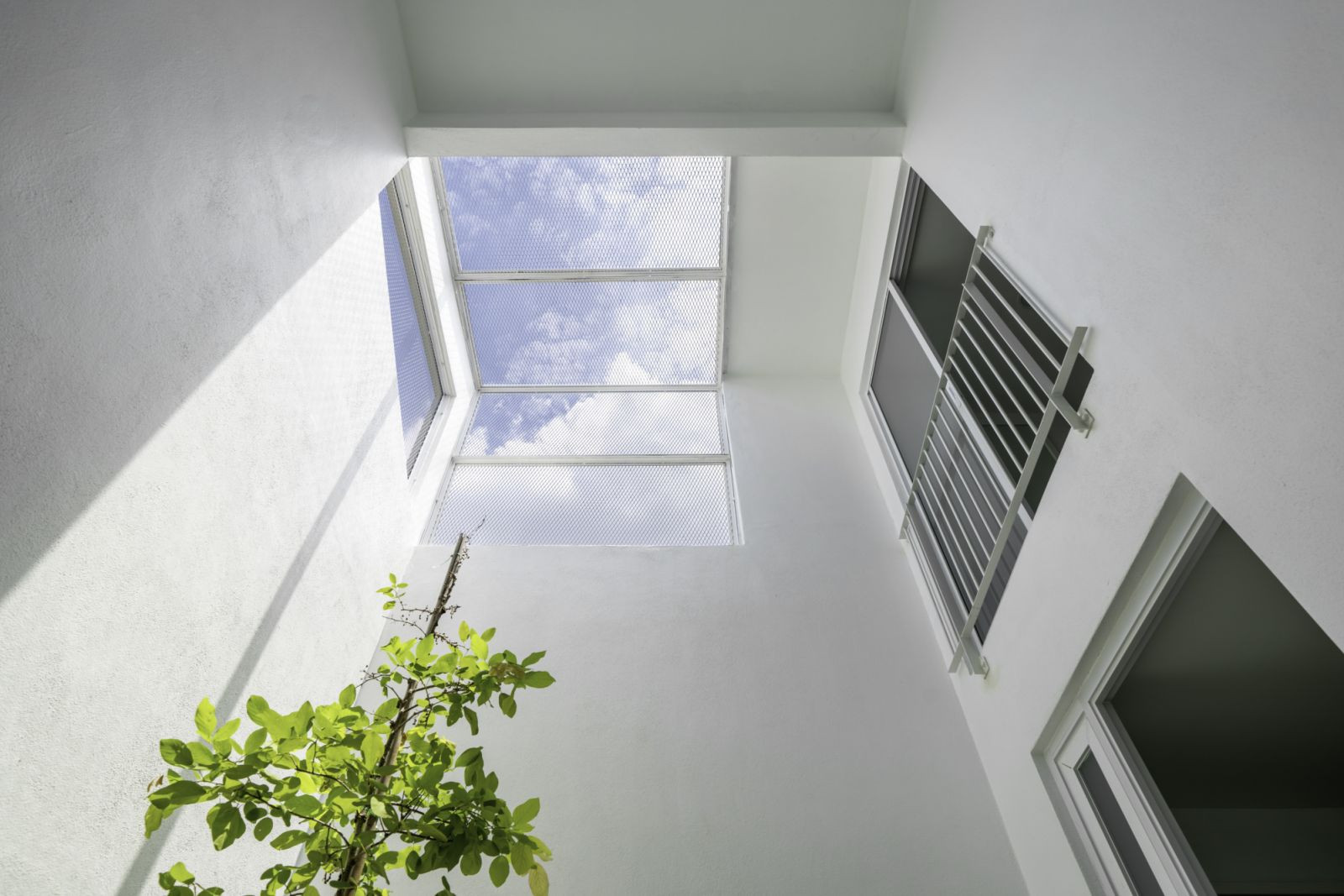 Carefully punched openings draw daylight and air into the ultra-minimalist interiors (Photos: BricksBegin)