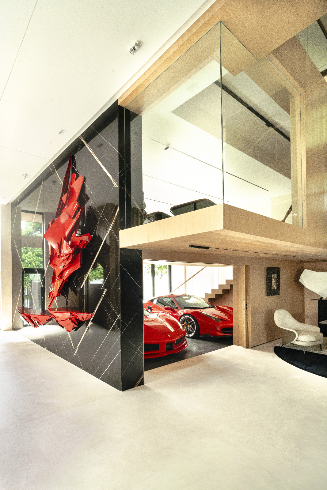 Red theory in action, the supercars’ colours are mirrored by the large hanging relief sculpture at the entry foyer of a home designed by Ed Calma