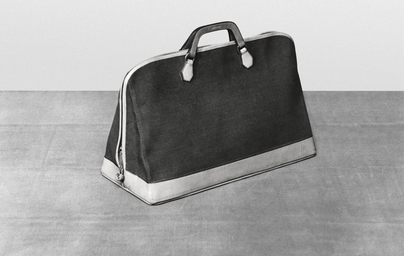 Squire Bag en toile de coton non enduite, marron (dimensions : 55 x 25 x 35 cm) - Le sac Alma lance en 1992 s'inspire du Squire Bag cree en 1934 par Gaston-Louis Vuitton. En 1955, cette forme retravaillee a ete rebaptisee Champs-Elysees - Photographie prise le 3 aout 1934.