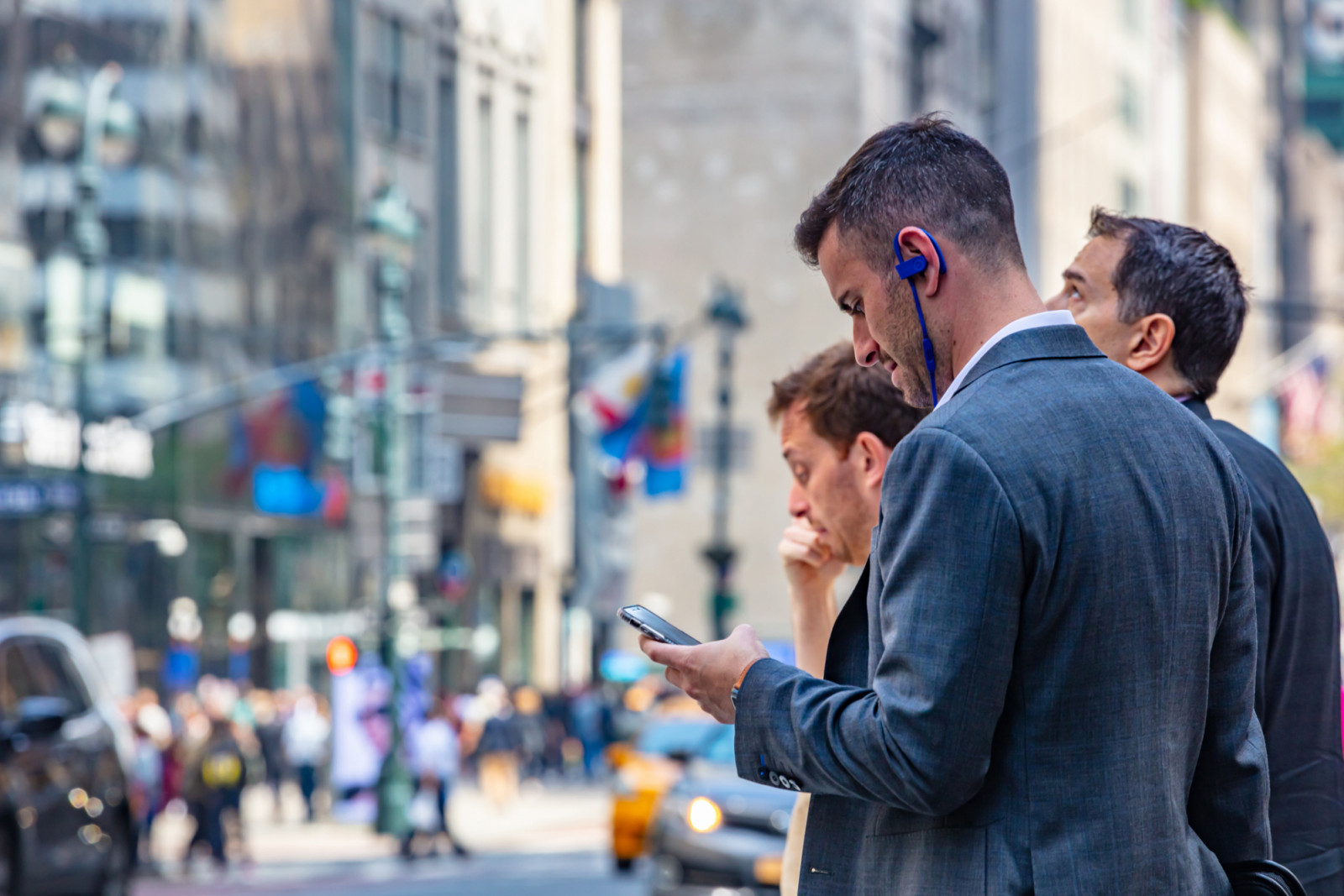 USA, New York, Wall street. May 2, 2019. Busy man in suit checking his mobile. Blur buildings and crowded streets, copy space