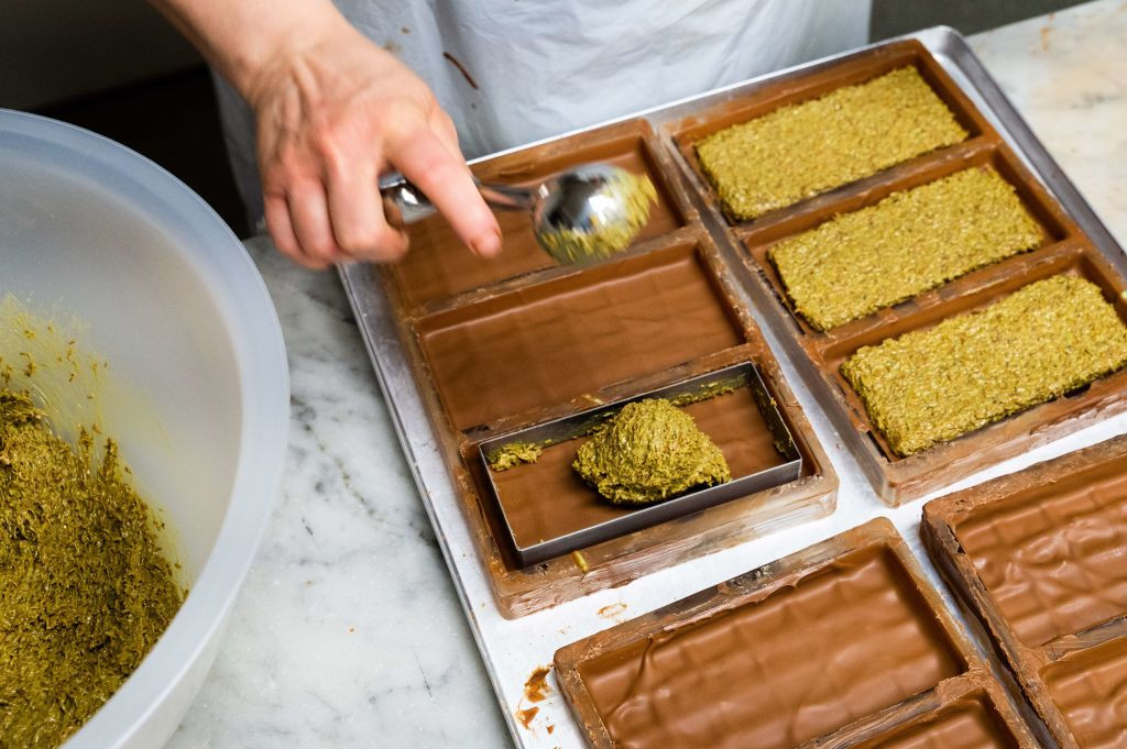PRODUCTION - 27 November 2024, Lower Saxony, Hanover: An employee of Manufatur Trüffel Güse fills the chocolate bars with a cream of pistachio paste and angel hair during the production of Dubai chocolate. Christmas preparations are in full swing at chocolate manufacturers. The hype surrounding Dubai chocolates continues unabated. Photo: Alicia Windzio/dpa (Photo by Alicia Windzio/picture alliance via Getty Images)