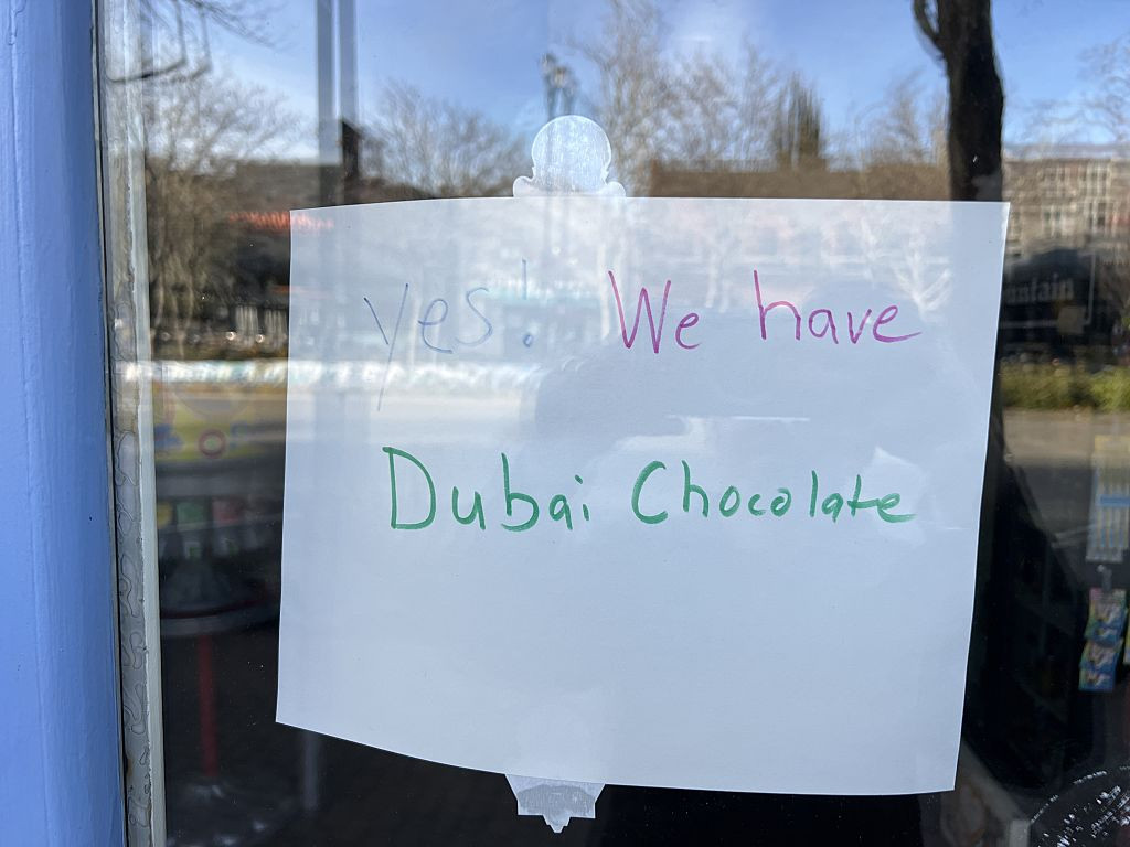 Handwritten sign reading “Yes, We Have Dubai Chocolate” displayed on a storefront window, Lafayette, California, March 20, 2025. (Photo by Smith Collection/Gado/Getty Images)