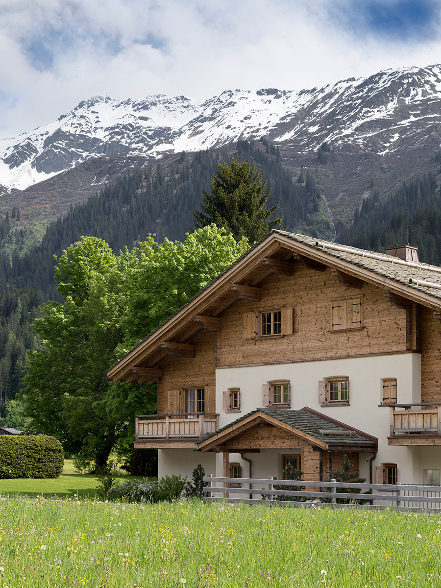 An external shot of the Klosters, Switzerland family chalet, designed by Tollgard Studio, paired with breathtaking views of the Swiss Alps