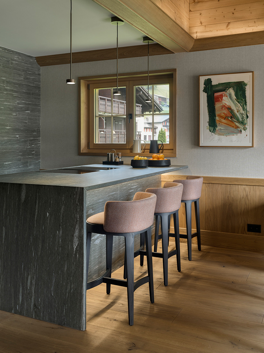 The kitchen overlooking the dining area of the Klosters, Switzerland family chalet, designed by Tollgard Studio