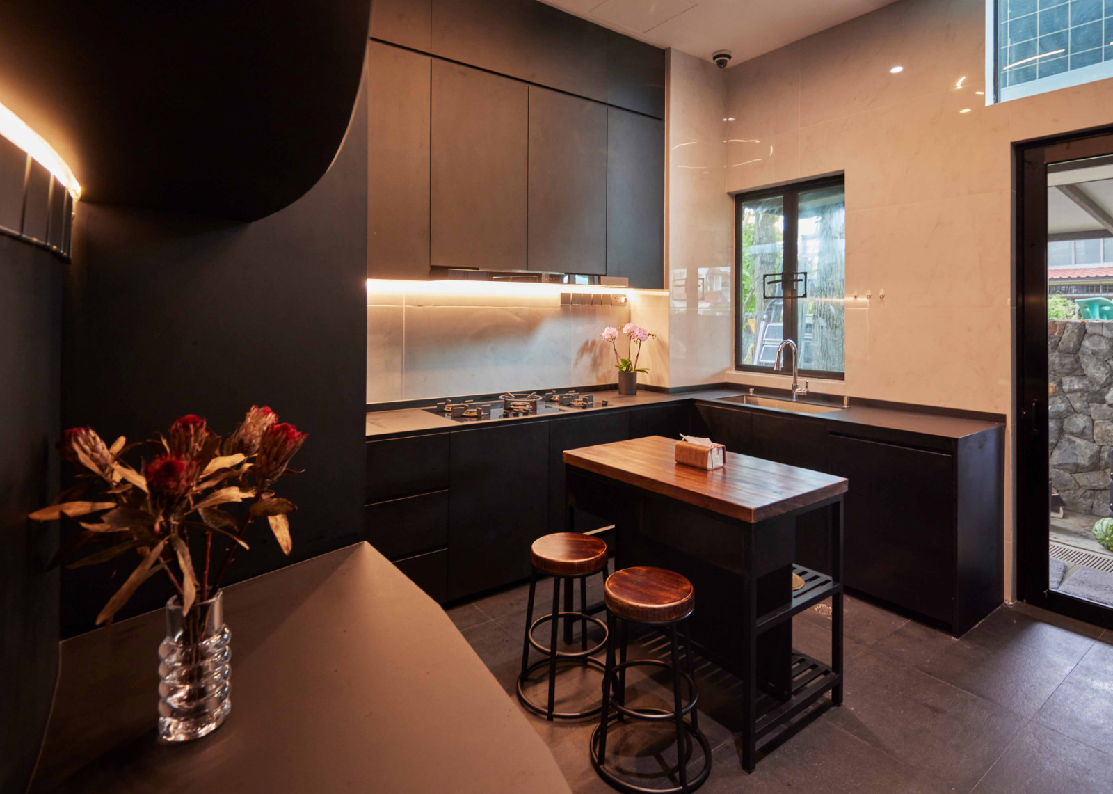 A dark material palette gives the kitchen a cocooning, intimate feel