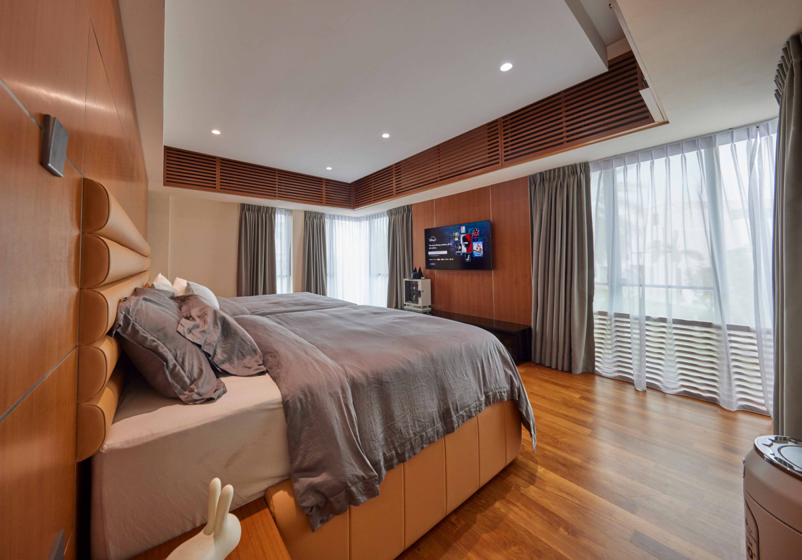 The bungalow’s master bedroom is wrapped in warm timber tones