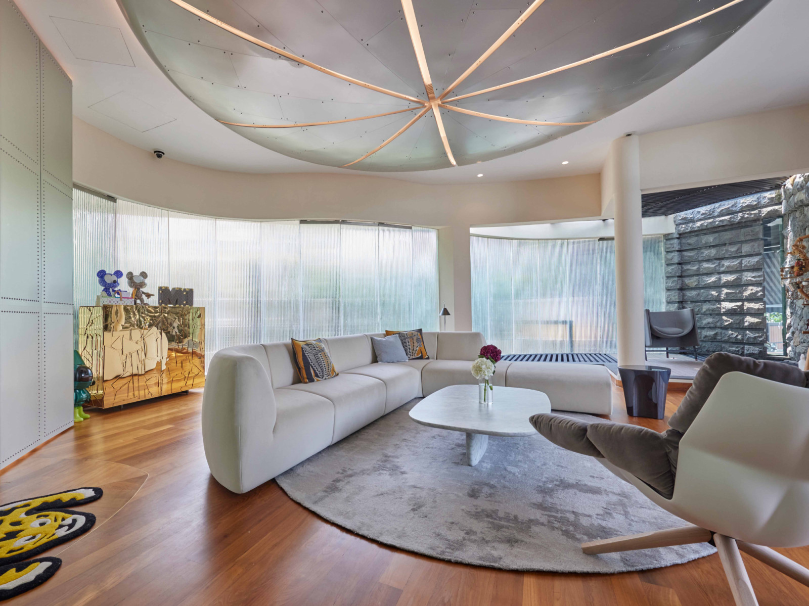 Beneath the Orange, the living room is anchored by Stellarworks’ Infinity sofa, while Edra’s gold Scrigno cabinet houses more Bearbricks in a sun-drenched corner