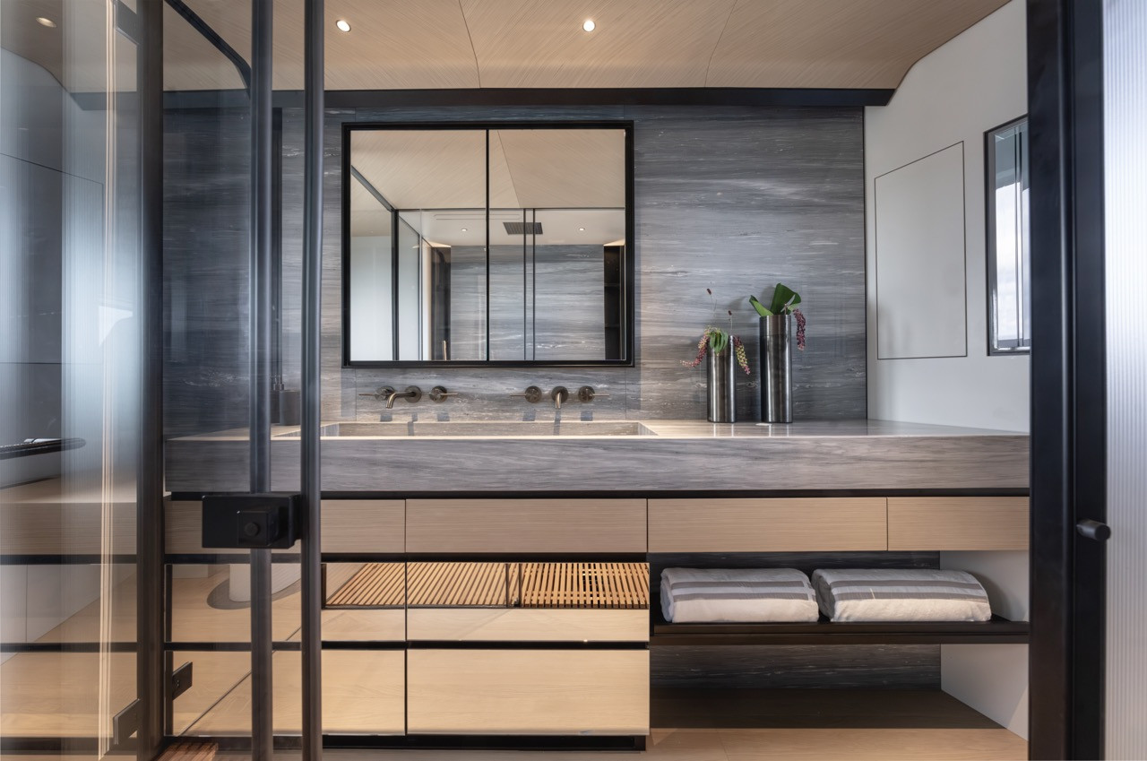 Stone with subtle movement lines the Azimut Grande 30M owner’s bathroom, where materials behave structurally rather than decoratively