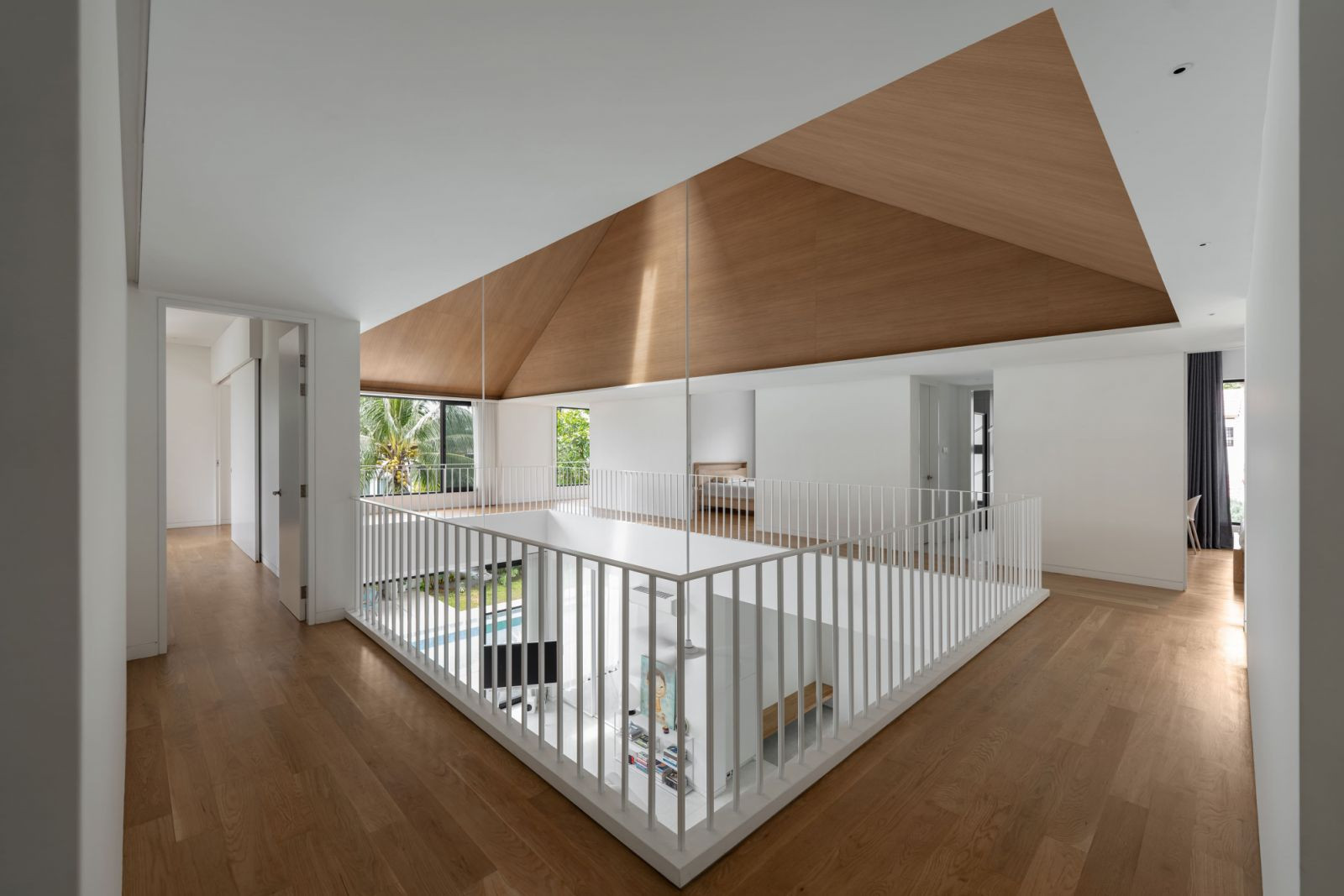 The timber-lined first floor loops around the central void (Photo: Bricksbegin)