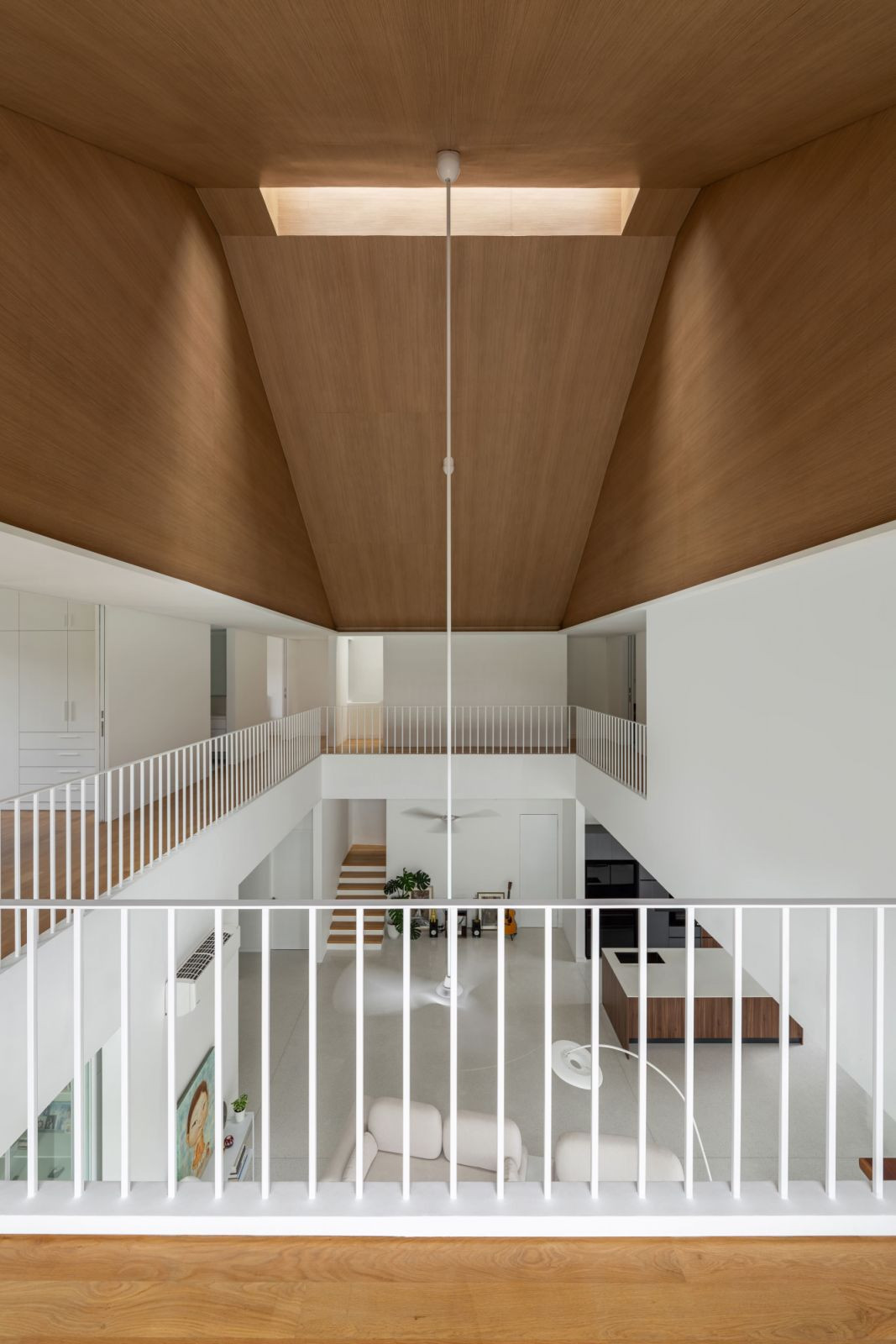 The three-storey void with a timber-clad pitched ceiling and strategically placed skylight (Photo: Bricksbegin)