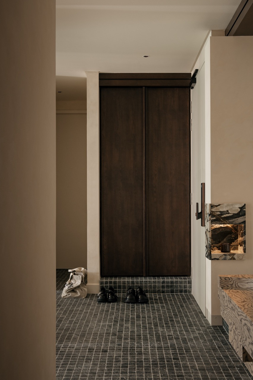 The entrance threshold shows the solid wood louvre sliding doors that can open the home office to the living area