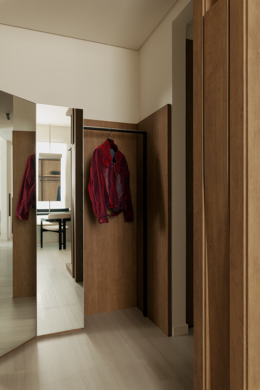 The corridor’s walnut-framed openings create sightlines through to the various rooms beyond