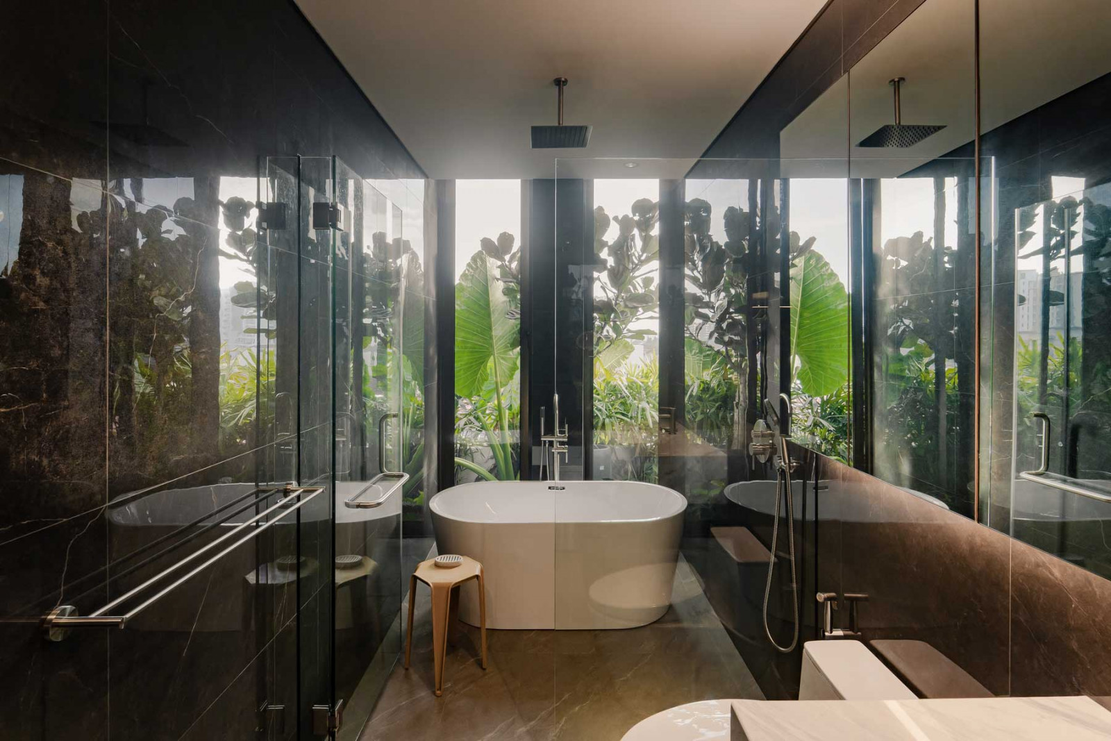 The master bathroom looks out to verdant vegetation, which provides privacy while allowing natural light to stream in
