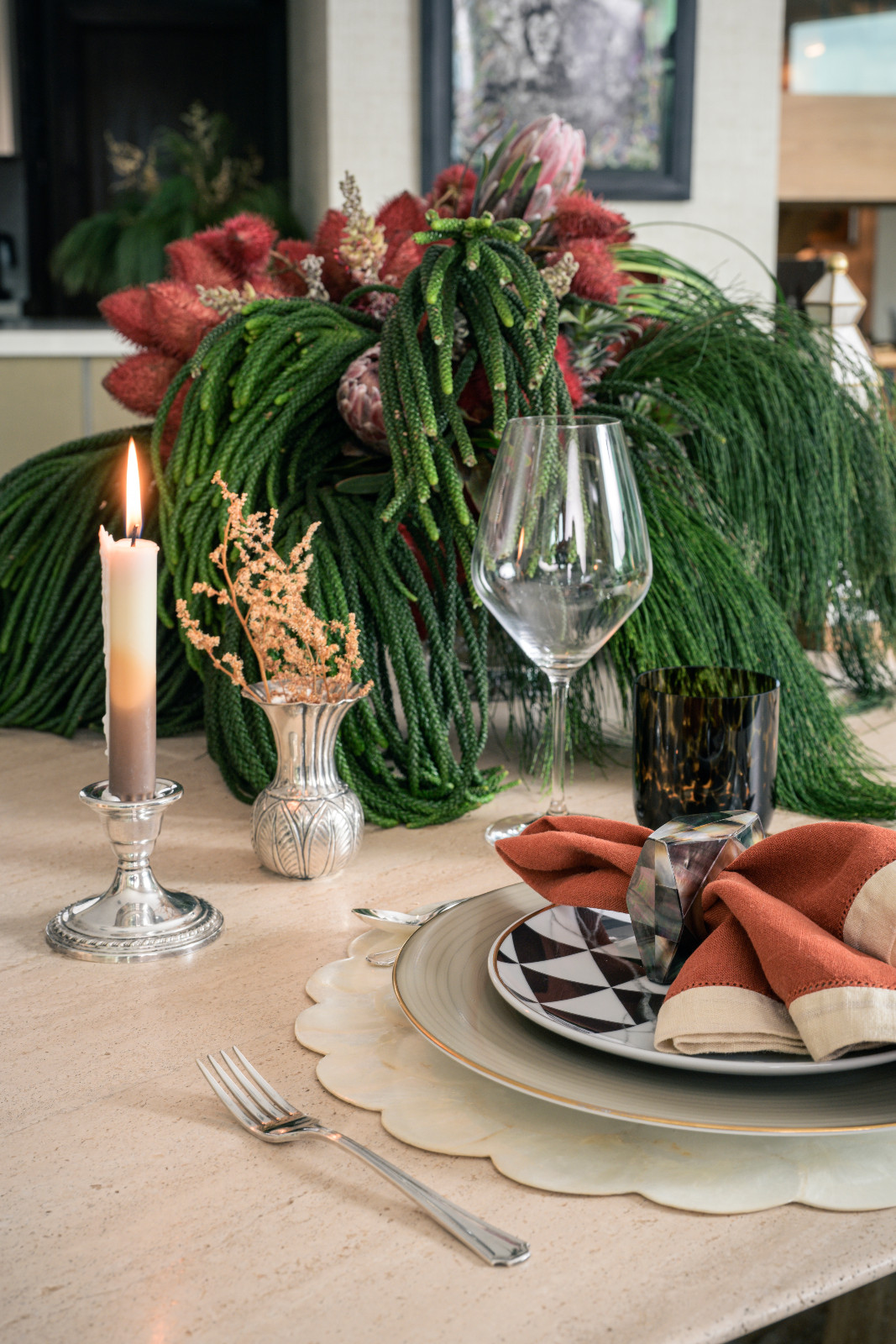A beautifully-lit candle on a demure silver candlestick reinforces warmth at Stephanie Kienle Gonzalez's table