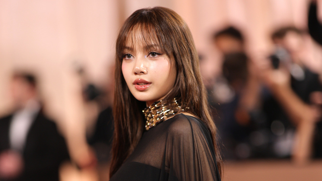 Lisa from Blackpink in a sheer black Jacquemus gown with stacked gold choker necklaces
