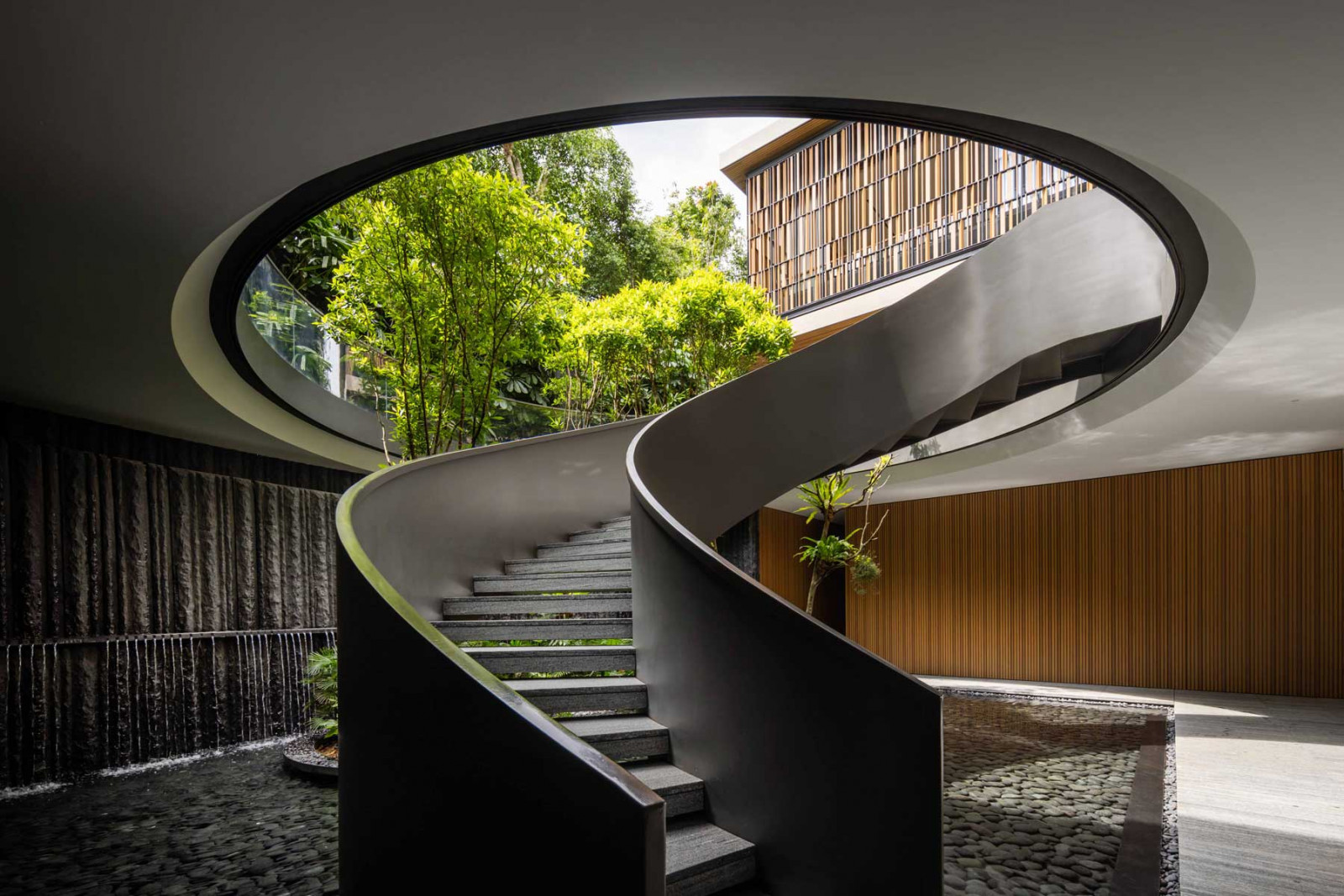 The circular opening framing the landscaped basement lends the space the ambience of an open-air art gallery