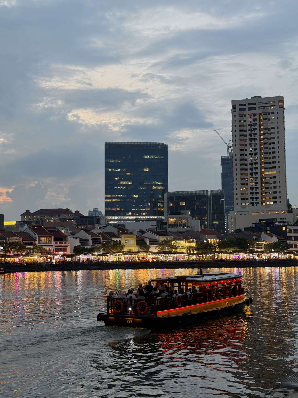 A luminous evening unfolds along the Singapore River, where heritage shophouses and modern towers coexist (Photo: courtesy of Singapore Airlines)