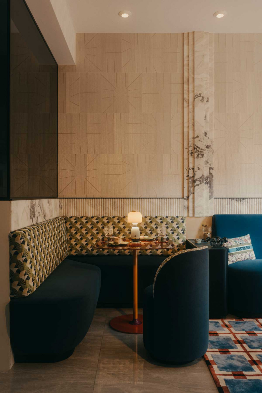 Subtle patterns on the wallcoverings act as a visual counterpoint to the vibrant motifs on the upholstery in this dining nook