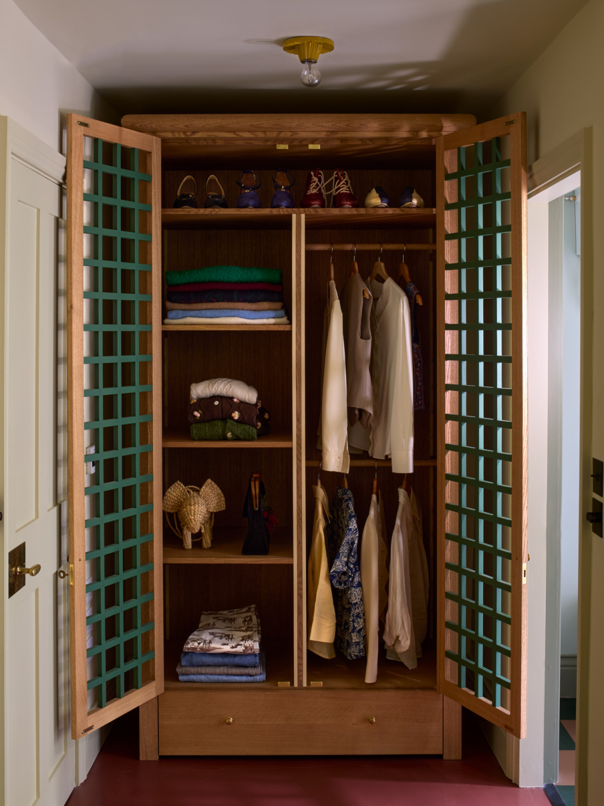 An armoire in Beata Heuman's home styled with ceremonial care, where everyday garments are arranged as treasured artifacts