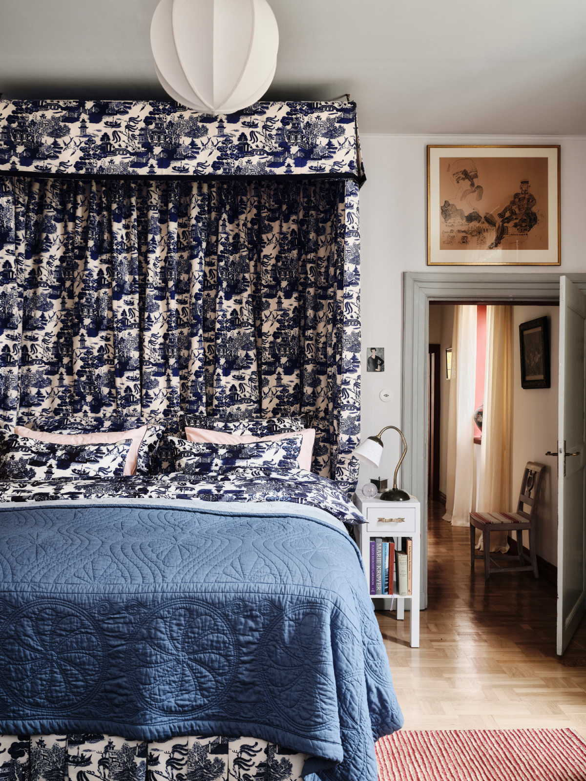 A grand bed sumptuously draped in blue toile in Beata Heuman's home