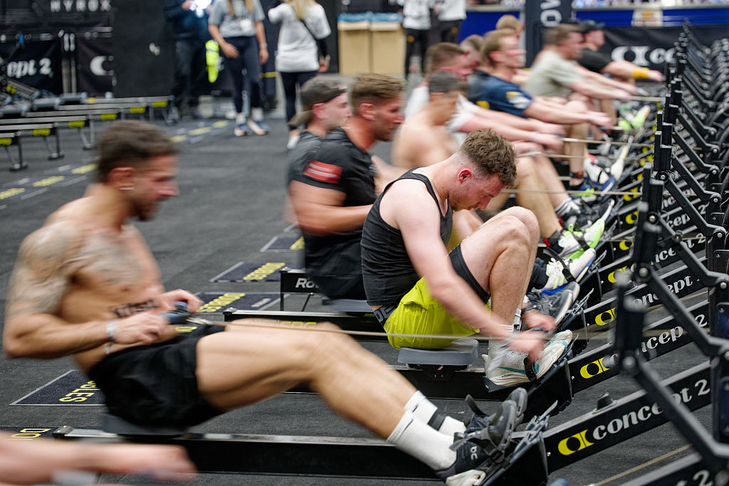 10 April 2025, North Rhine-Westphalia, Cologne: Participants row on rowing machines in a HYDROX competition at the "Fibo 2025" fitness trade fair. HYROX is part of indoor fitness and combines eight kilometers of running with eight functional workout stations. The trade fair presents new trends in fitness, wellness and health to trade visitors and consumers. Photo: Henning Kaiser/dpa (Photo by Henning Kaiser/picture alliance via Getty Images)