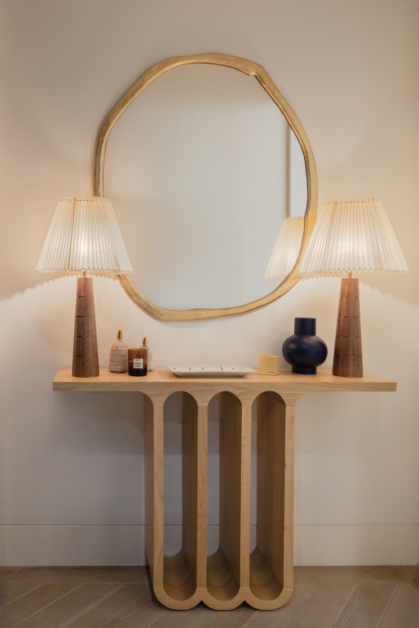 Một chiếc bàn console thiết kế hình vòm kết hợp cùng những hệ đèn tạo hình điêu khắc trở thành tâm điểm định hình cho khu vực chiếu nghỉ.
