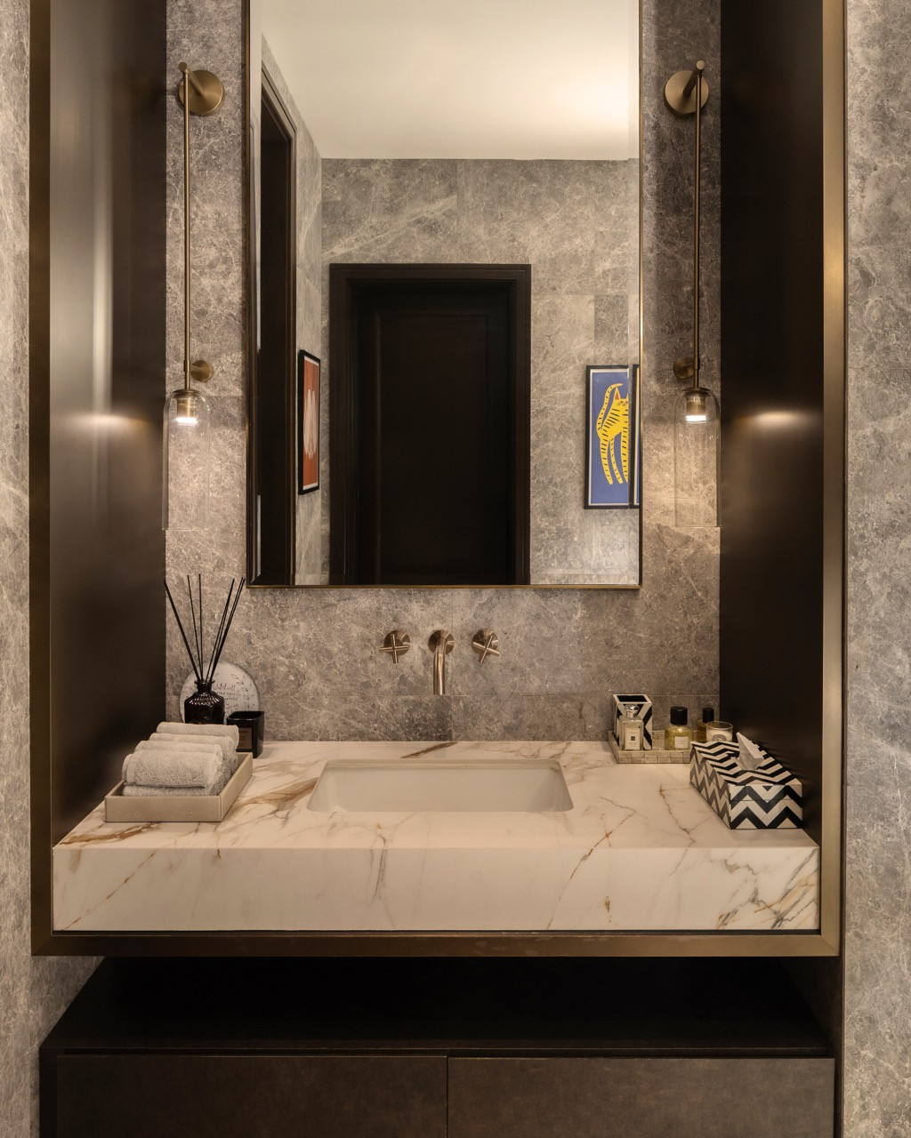 Phòng powder room toát lên vẻ tinh tế với mặt bàn đá cẩm thạch và tường ốp đá xám, được điểm xuyết bởi hệ phụ kiện bằng đồng thau tạo nên sự tương phản đầy đẳng cấp.