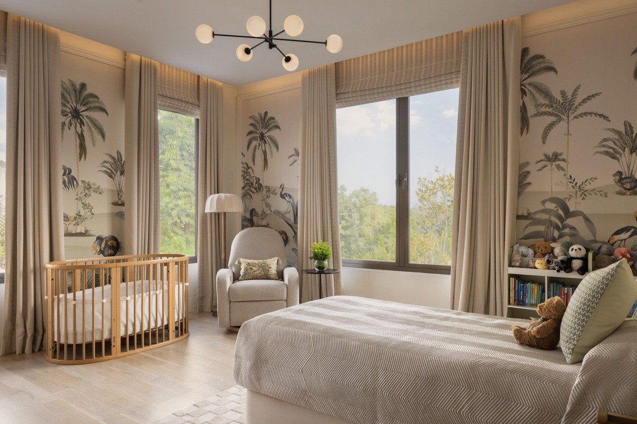 The nursery features floor-to-ceiling botanical wallpaper depicting palms, birds, and tropical foliage, paired with a rounded wooden crib