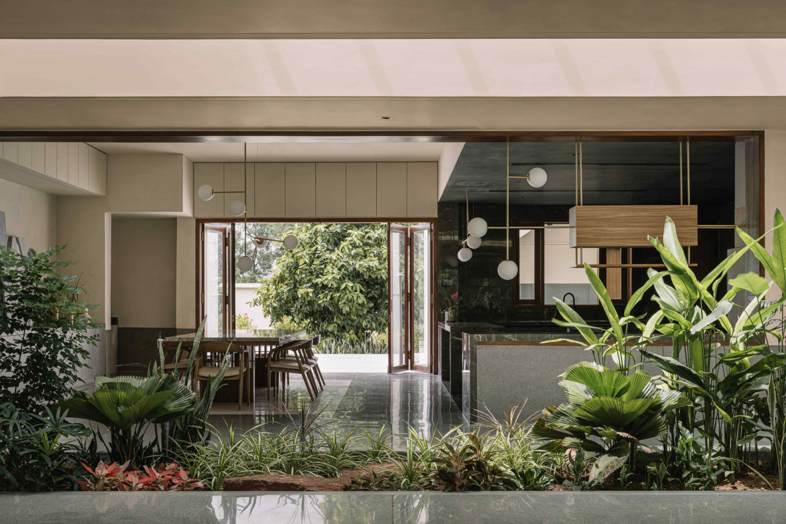 The dining and kitchen area with bespoke lighting in brass and wood