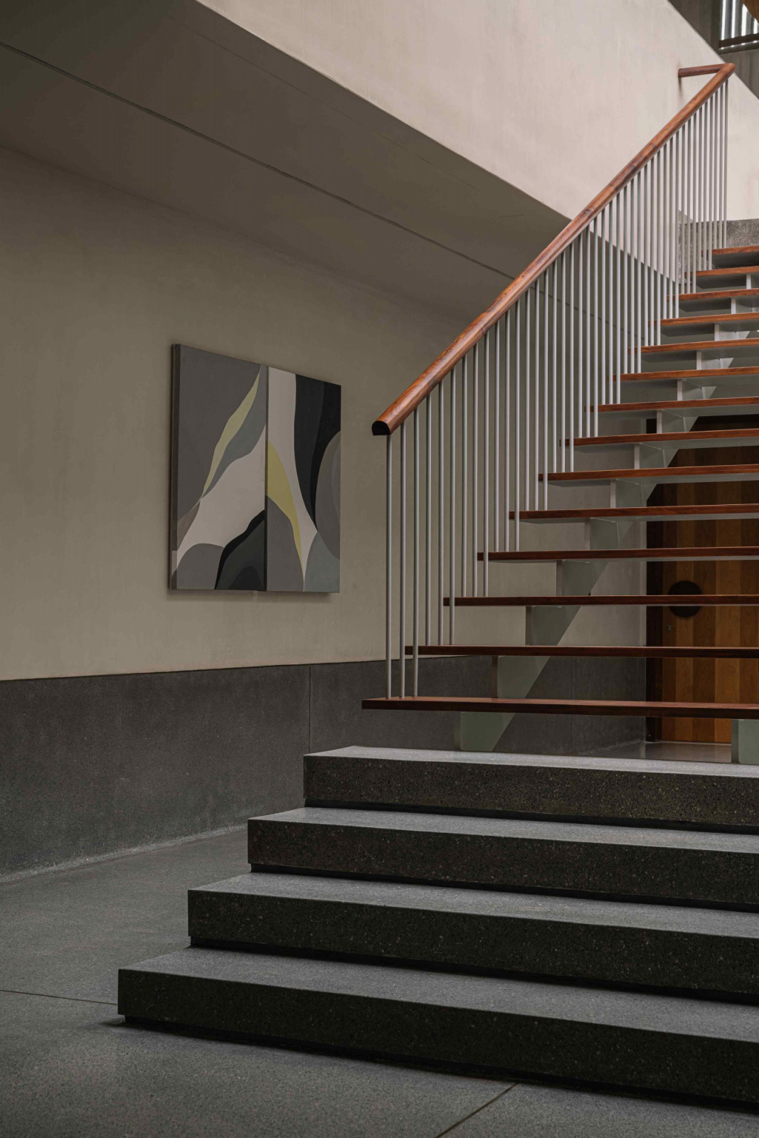 A solid terrazzo base transitions to metal and wooden floating treads