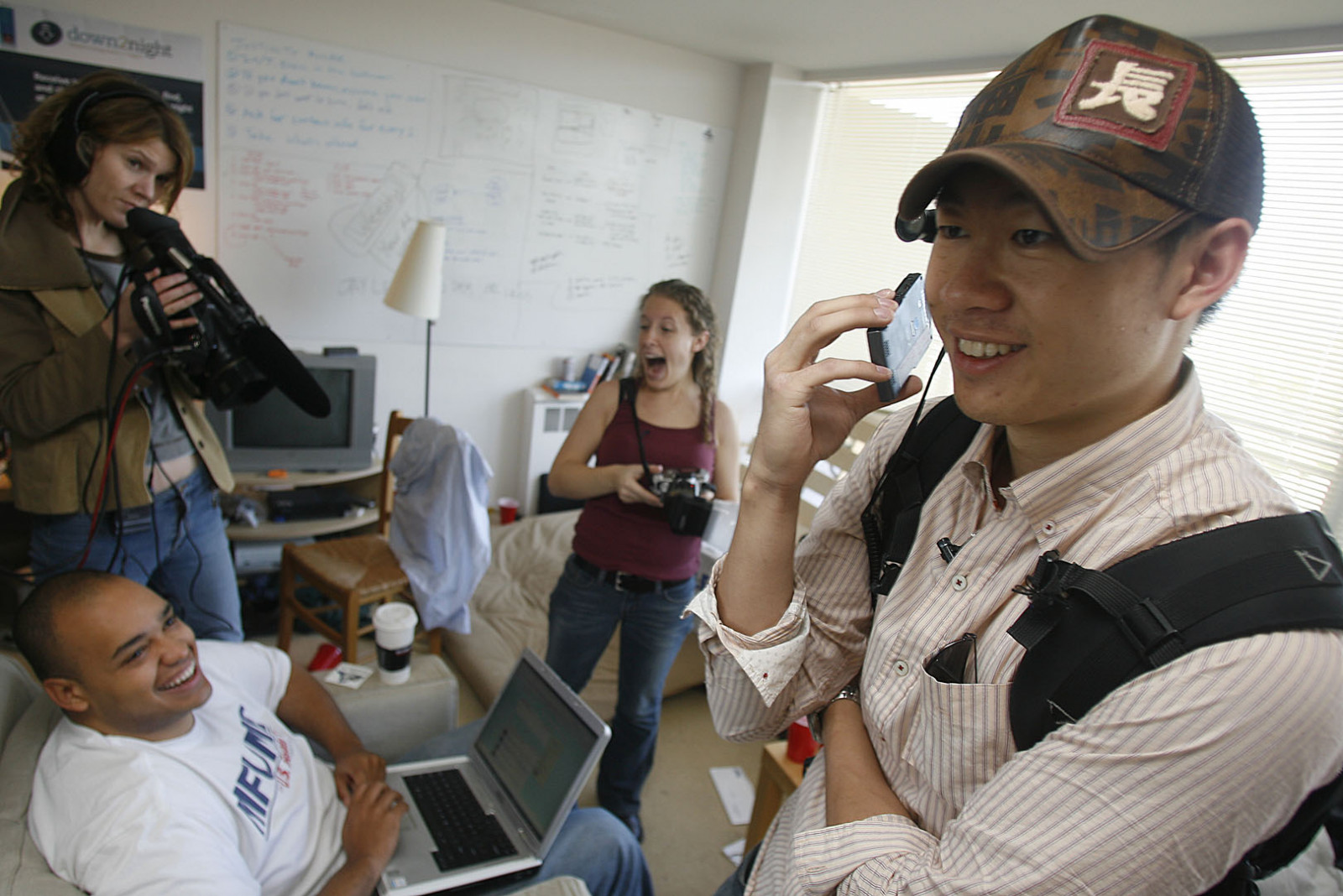 Justin Kan, co-founder of Justin.tv, streams his daily life through a webcam attached to his baseball cap. Beside him is another co-founder, Michael Seibel, and two photographers chronicling what Kan is doing (Photo: Getty Images)