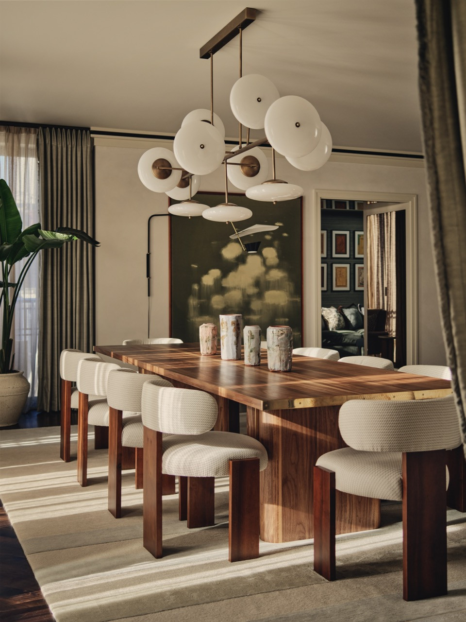 The formal dining space, one of three distinct zones within the main living area, with cream upholstered chairs