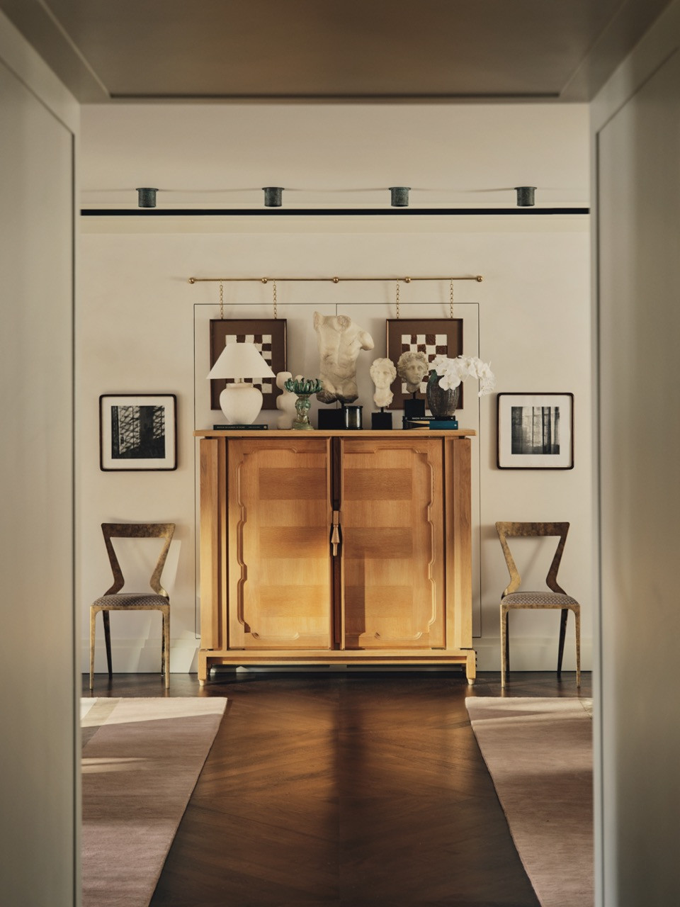 The entrance hall has a timber cabinet displaying artwork and decorative objects
