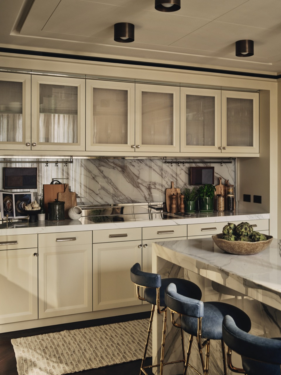 The kitchen with cream cabinetry and marble backsplash