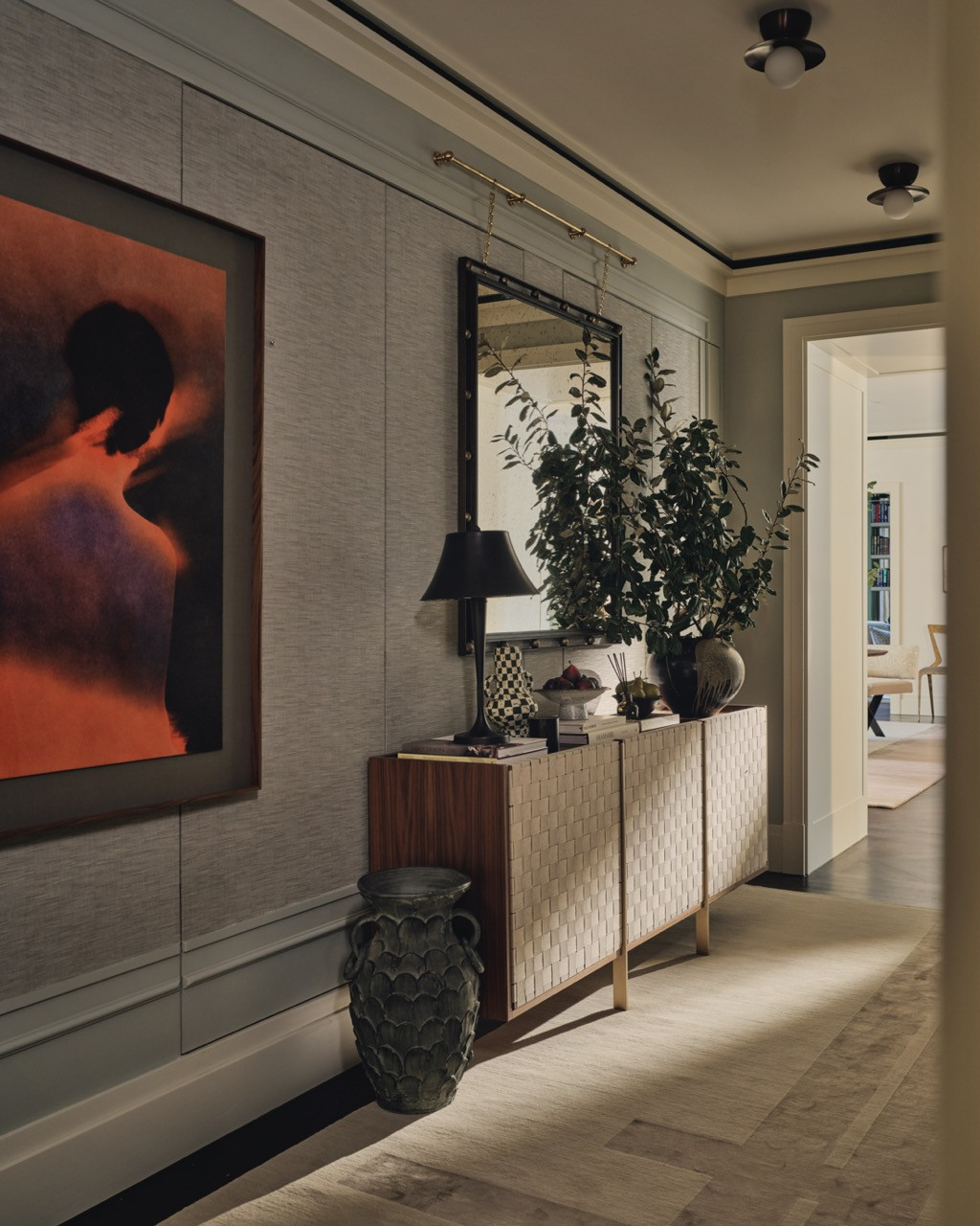 The entrance corridor features a gallery-style arrangement with seven curated artworks and a bespoke runner rug