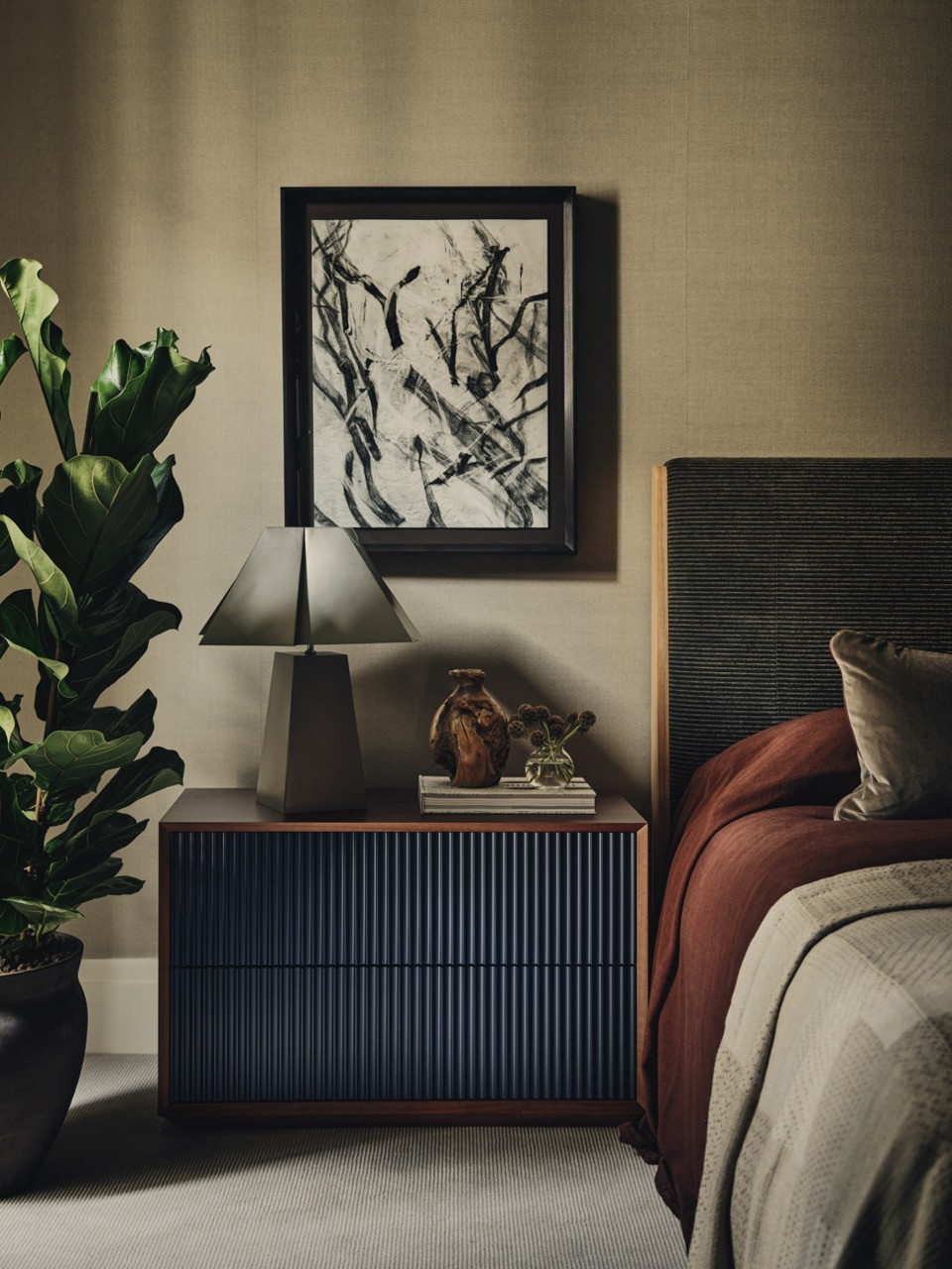 Bedroom storage featuring timber cabinetry, decorative objects, and artwork