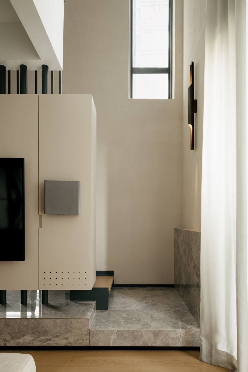 Living area showing how the TV wall integrates with the staircase as one architectural element