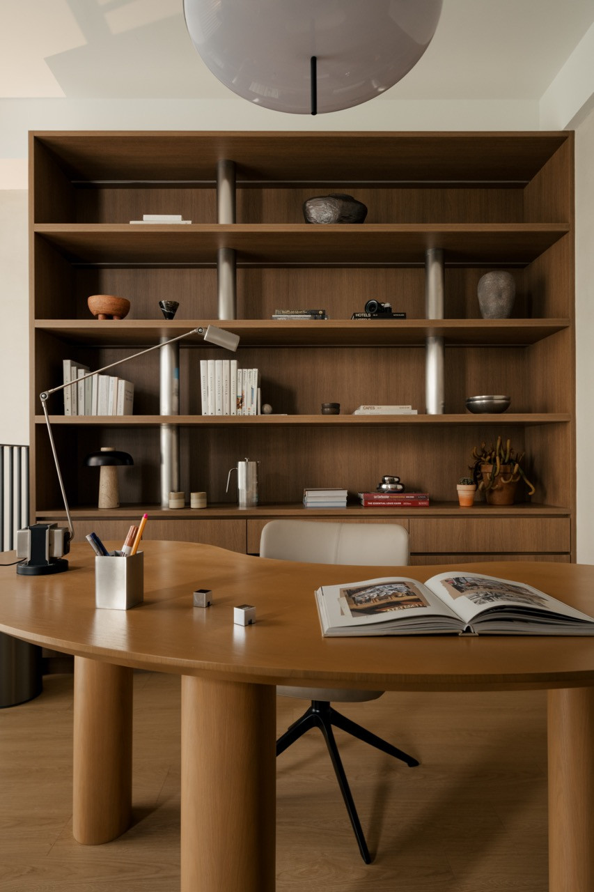Mezzanine study desk with integrated timber shelving wall providing extensive storage