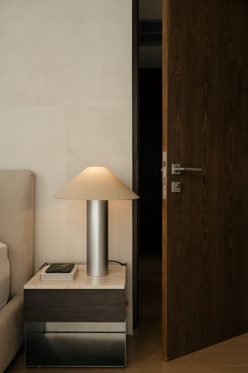 Bedroom nightstand with cylindrical lamp and timber door frames