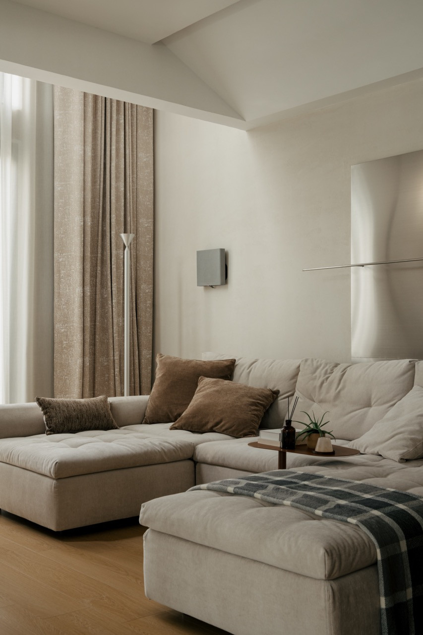 Sectional sofa from King Living with neutral textiles and double-height curtains