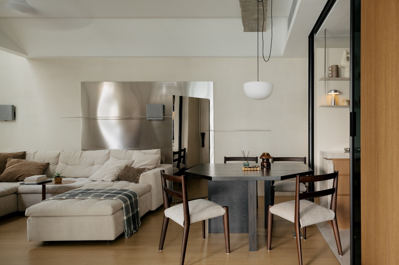 Stainless steel TV backdrop creating reflection in the compact living space
