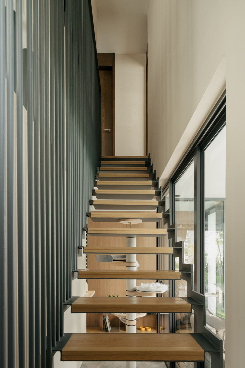 The existing straight steel staircase with timber treads is integrated into the apartment’s design