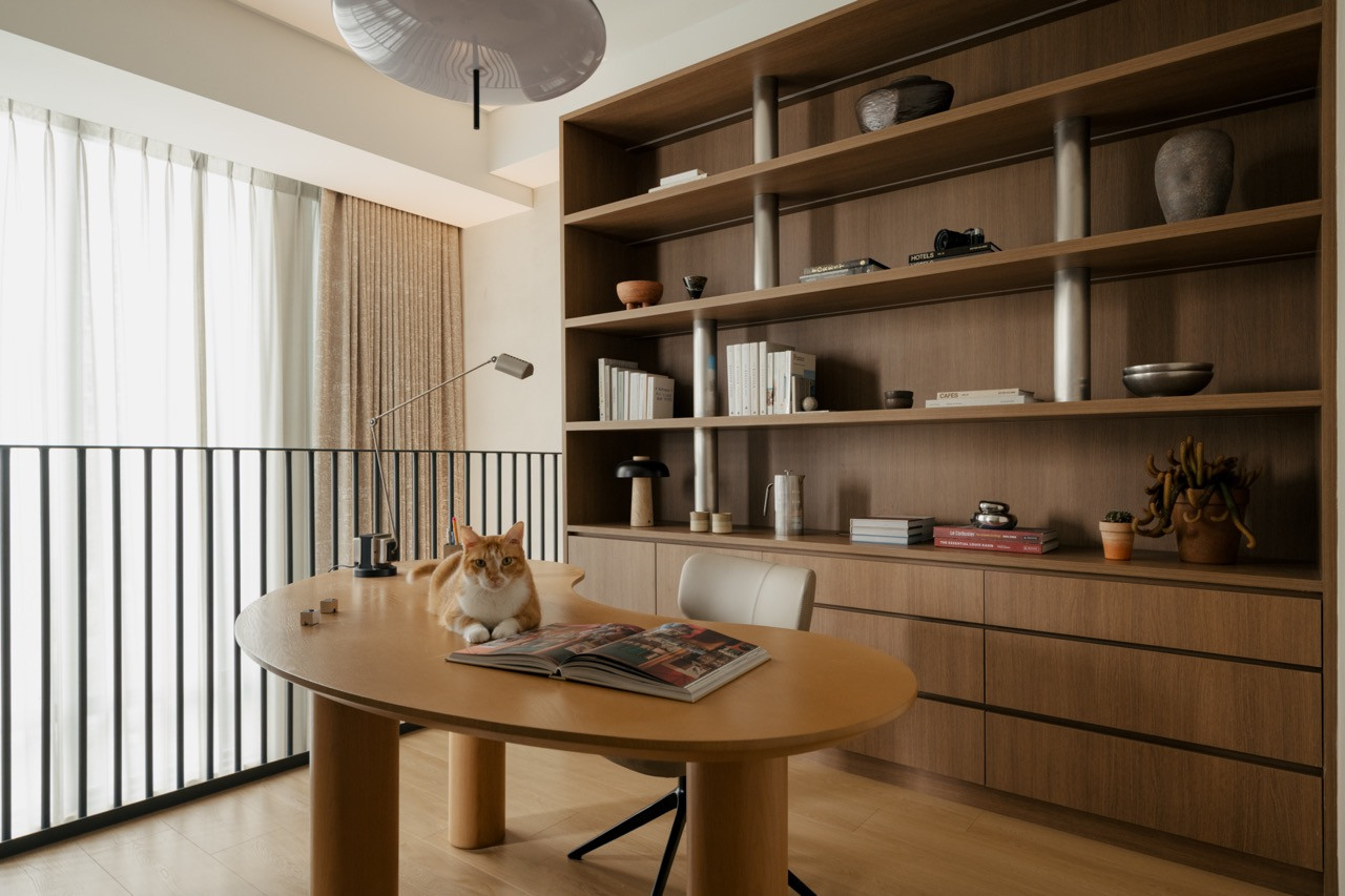 Mezzanine study area with circular timber table and built-in shelving with stainless steel rod supports