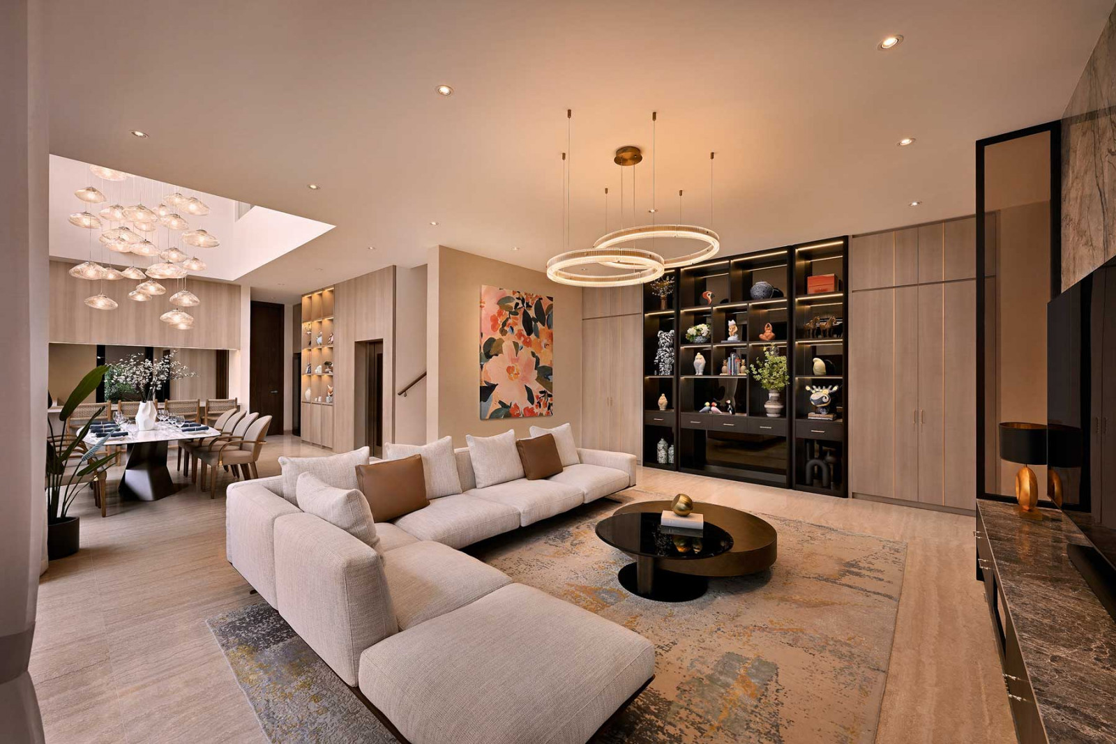 The elegant living room, anchored by an L-shaped sofa, flows seamlessly into the dining area