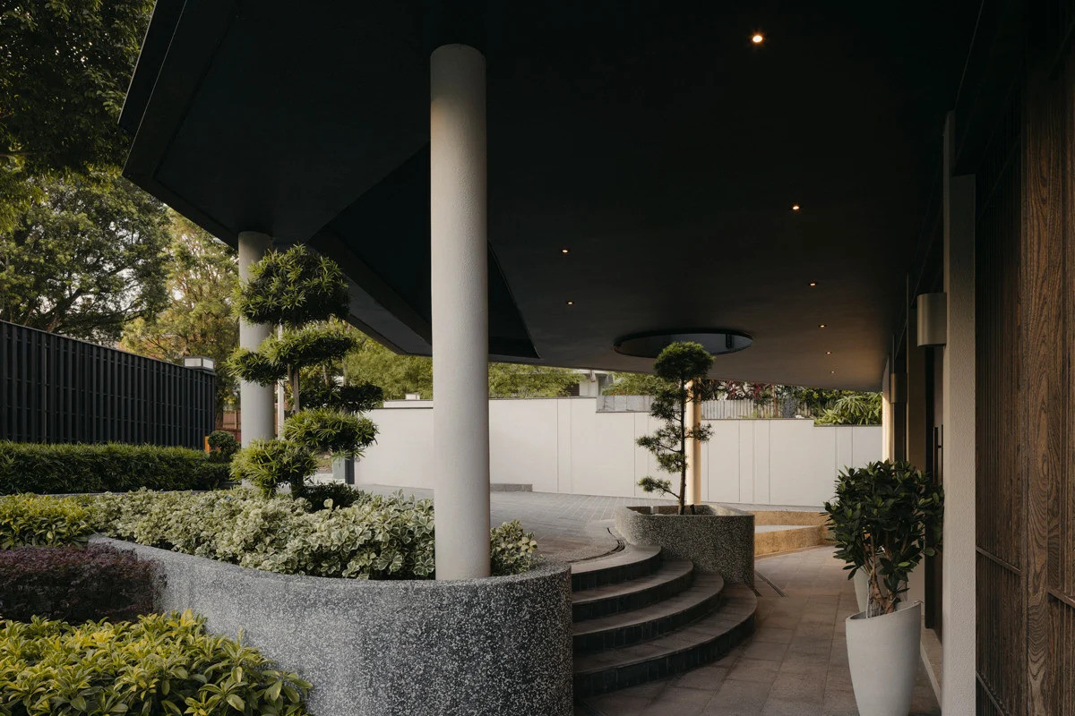 The site’s gentle slope unfolds into landscaped steps that usher guests towards the main entrance