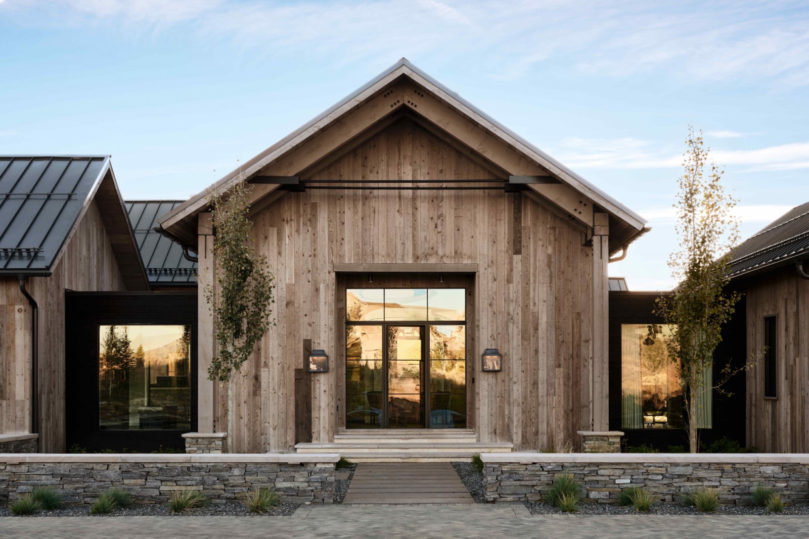 Weathered reclaimed wood siding offset by crisp industrial tie-rods and restrained black metal accents