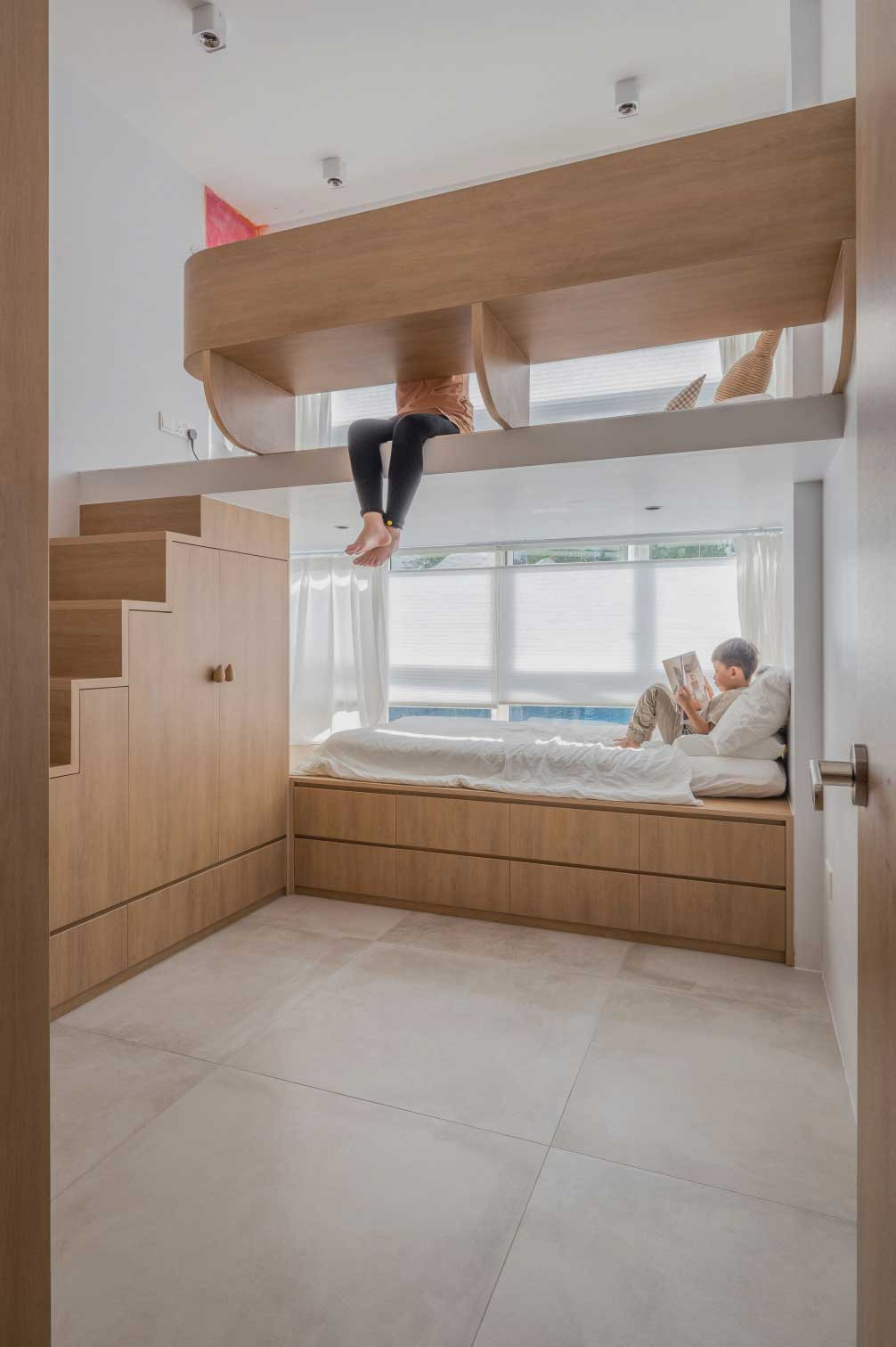 Large swathes of wooden panelling conceal plenty of storage space in the children’s bedroom