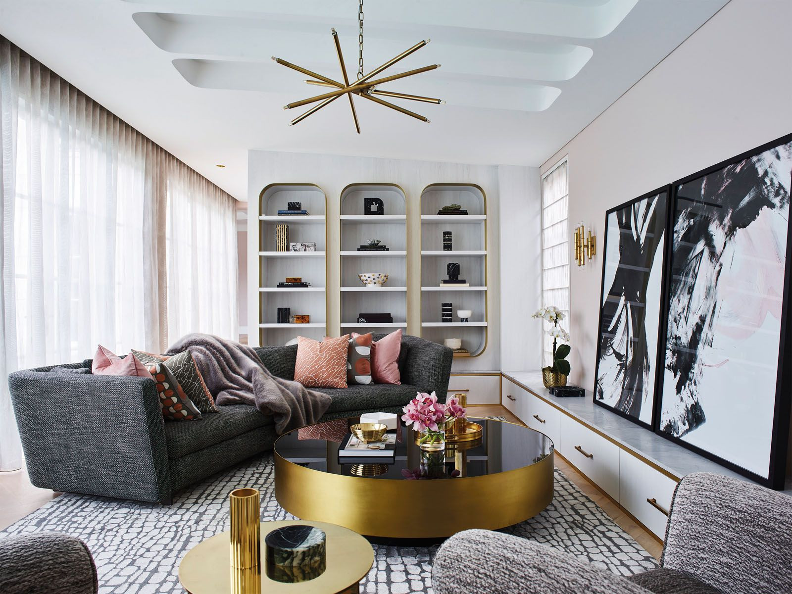 In the living room, a modern chandelier from James Said mirrors the wall sconce from Jonathan Adler in this Sydney home