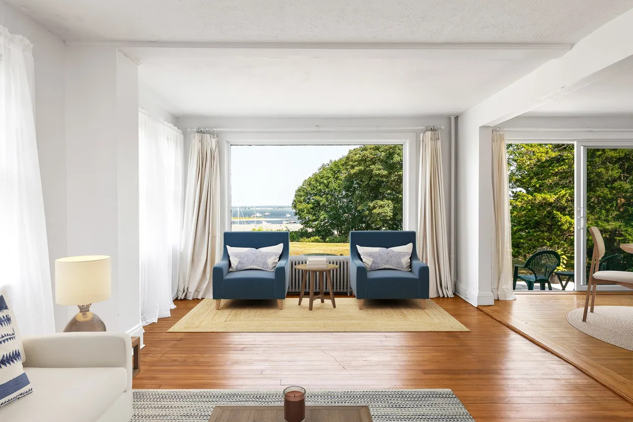 Expansive living room with original hardwood floors and large windows offering panoramic ocean views of Fisher’s Island and the Rhode Island Sound. (Source: realtor.com)